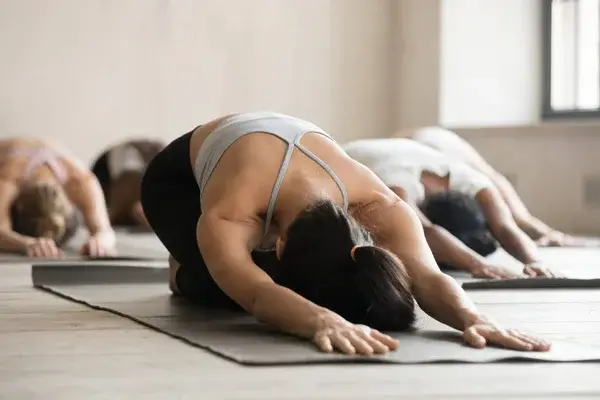 Grupa osób podczas zajęć jogi w sali fitness